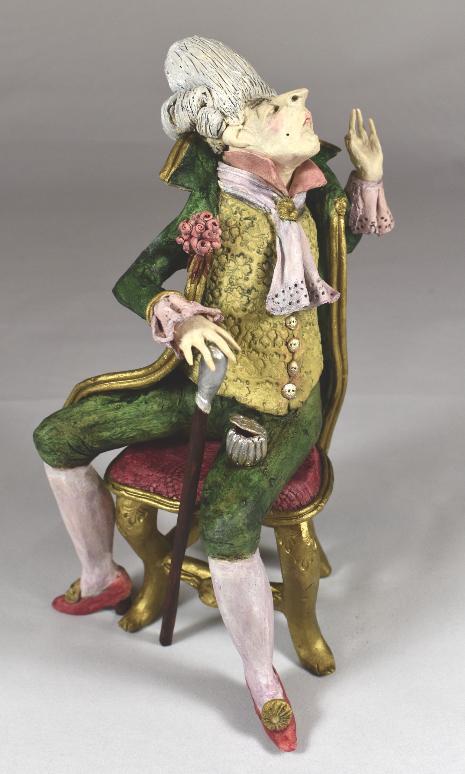 A clay male figure in 18th century clothing