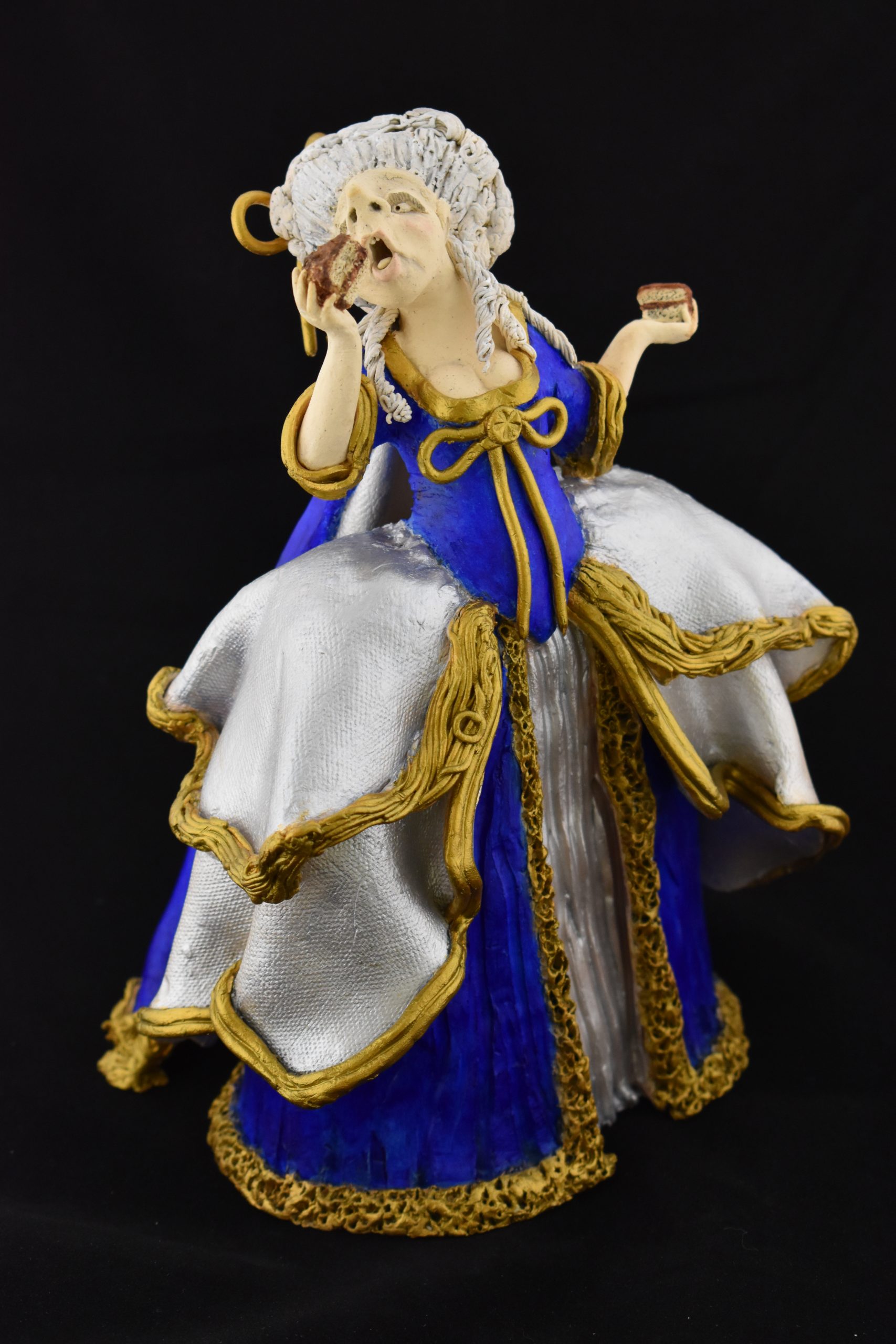 A clay female figure in 18th century clothes