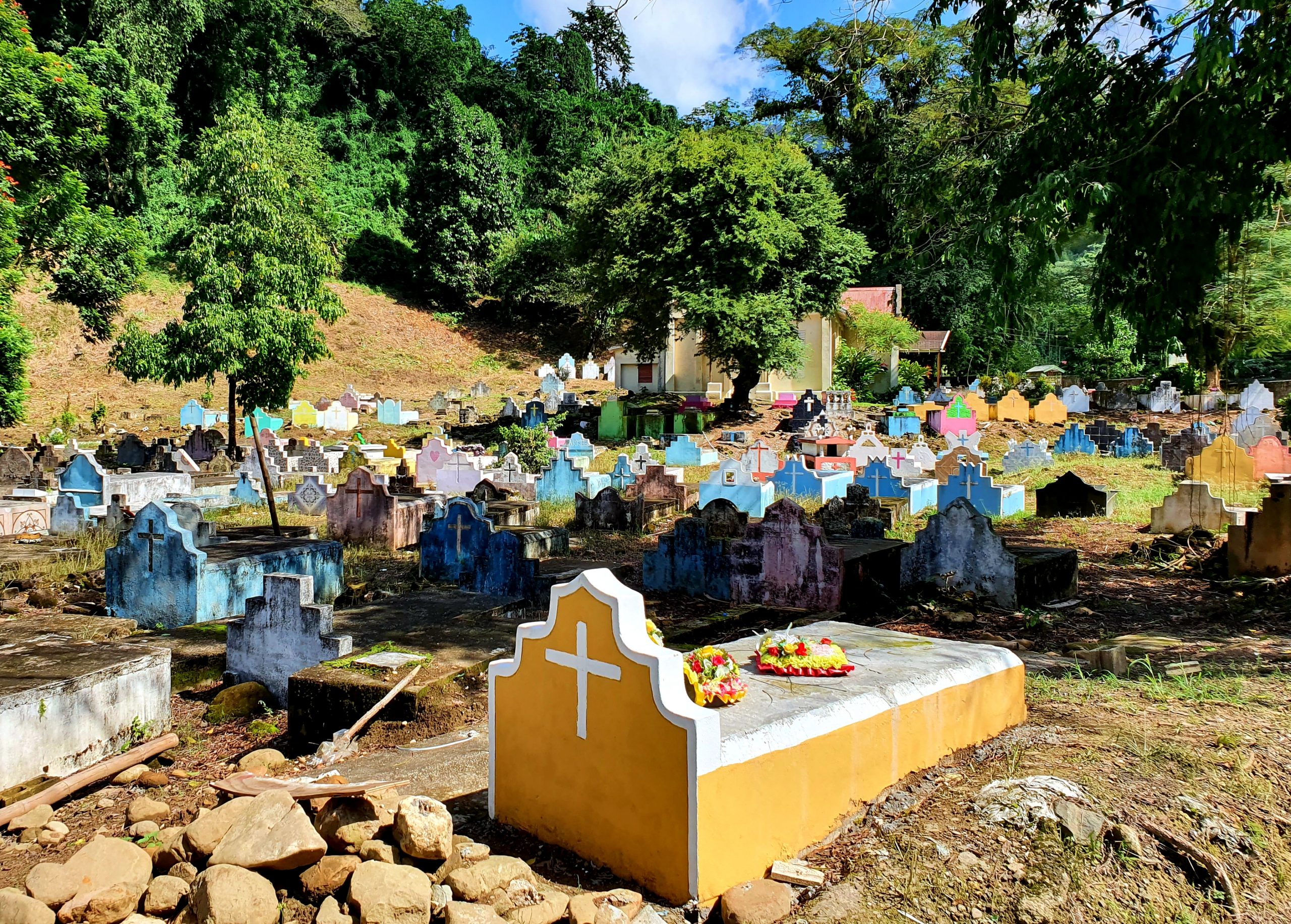 photograph of a cemetery with a yellow raised coffin in the foreground