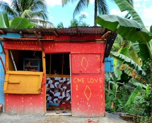photograph of a red building with One Love painted on it
