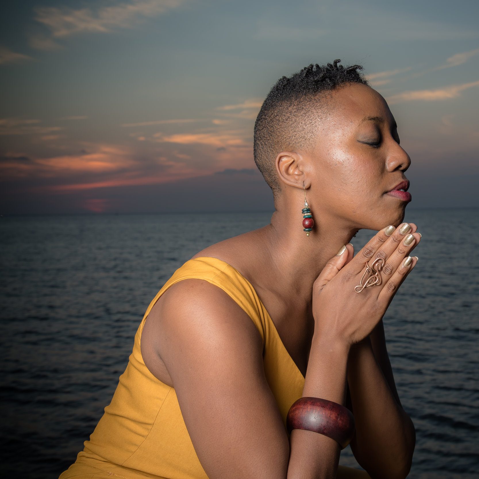 A woman in a yellow shirt against a background of water