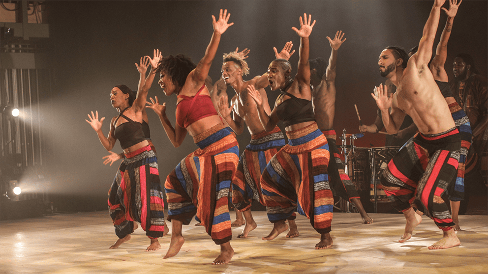 Group of people on a stage performing a dance routine