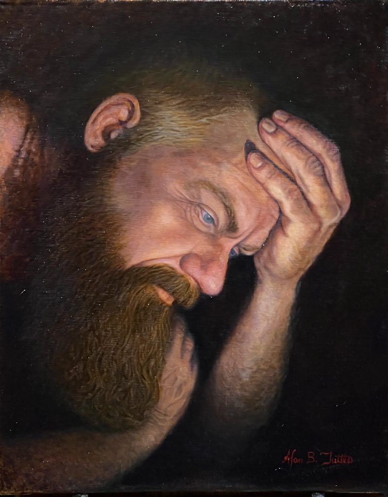 Realistic portrait of a bearded man in profile, his head bowed and one hand pressed to his forehead in a contemplative pose. Warm light falls across his face and hand against a nearly black background, emphasizing a somber, introspective mood.