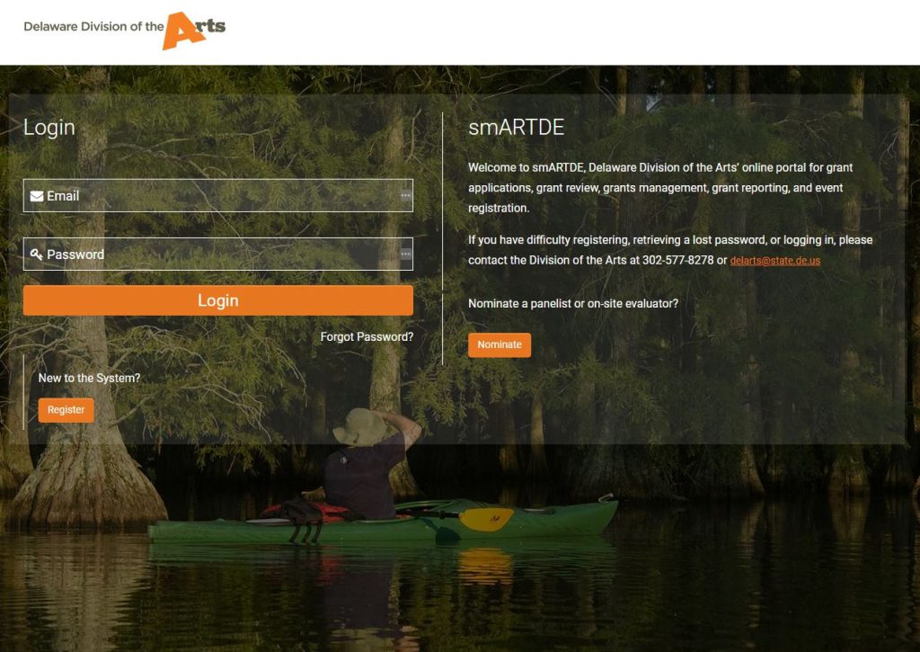 Screenshot of the Delaware Division of the Arts smARTDE online portal login page. The page features email and password fields, orange Login and Register buttons, a “Forgot Password?” link, and text describing the portal’s use for grant applications, review, management, reporting, and event registration, over a background image of a person kayaking through a wooded wetland.
