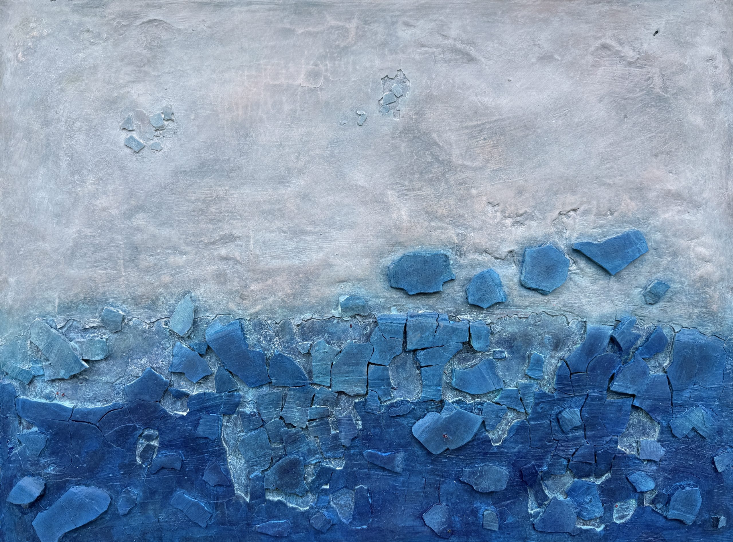 A piece of artwork that is blue in nature.  The blue is darker on the bottom with a grey blue up top.