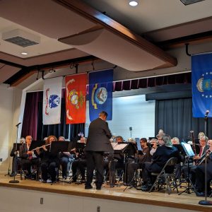 a group of musicians sitting underneath military flags