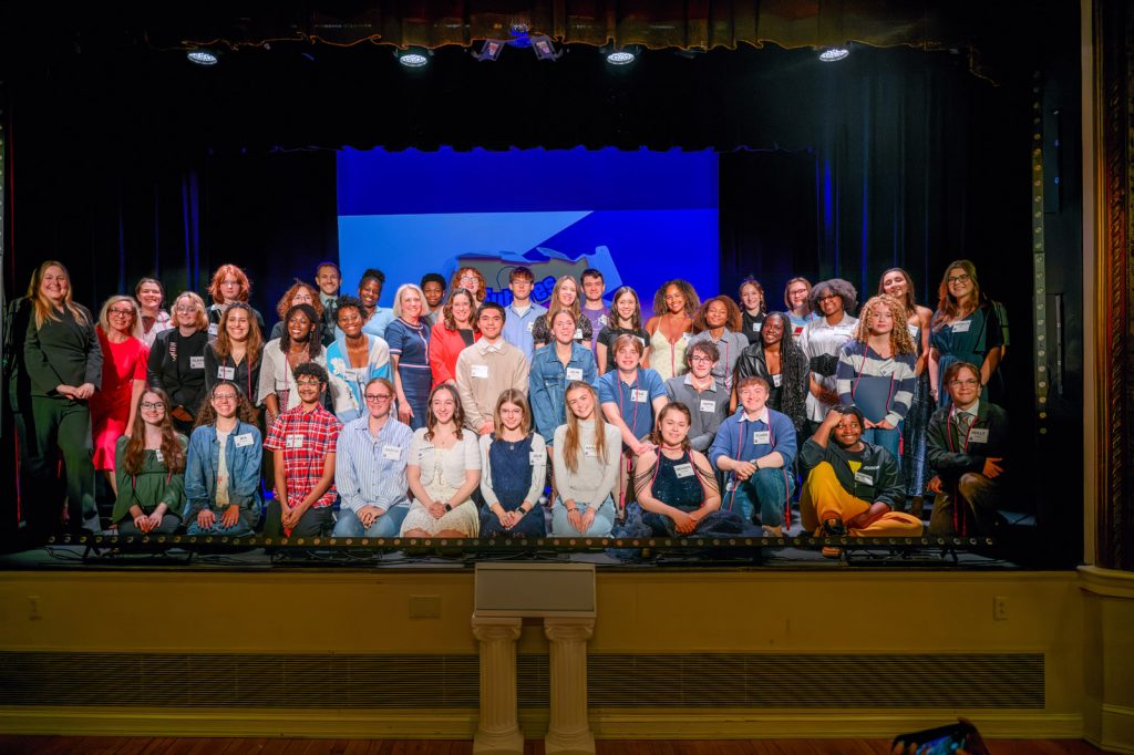A group of students and adults on stage