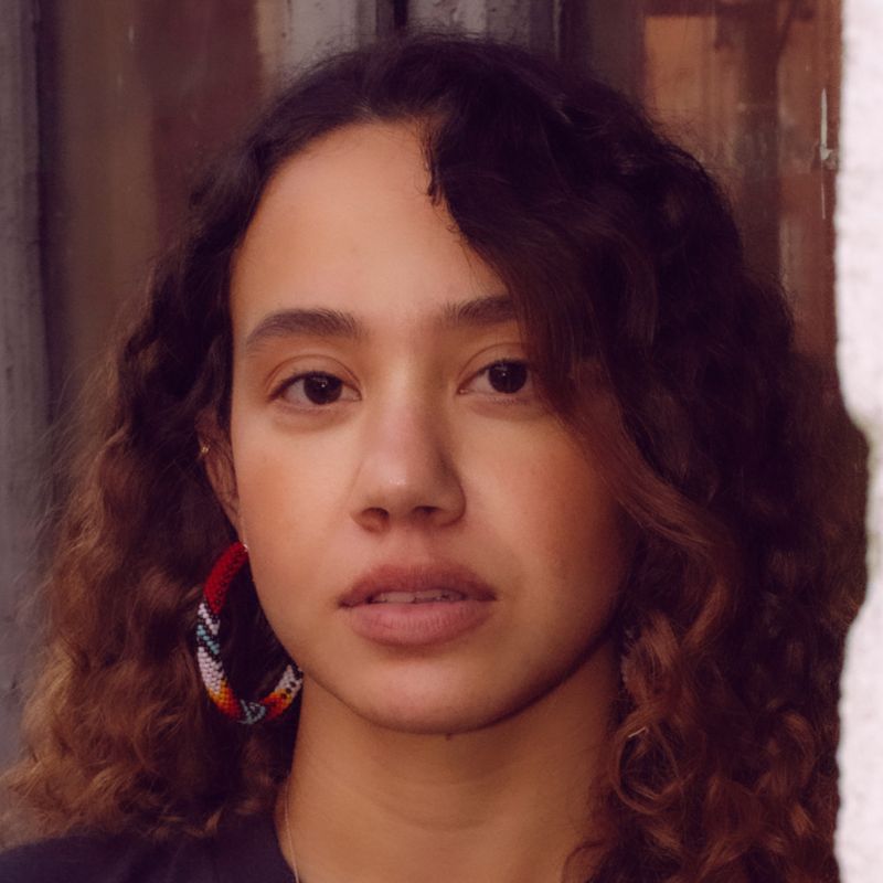 A young Native American with hoop earrings, inside.
